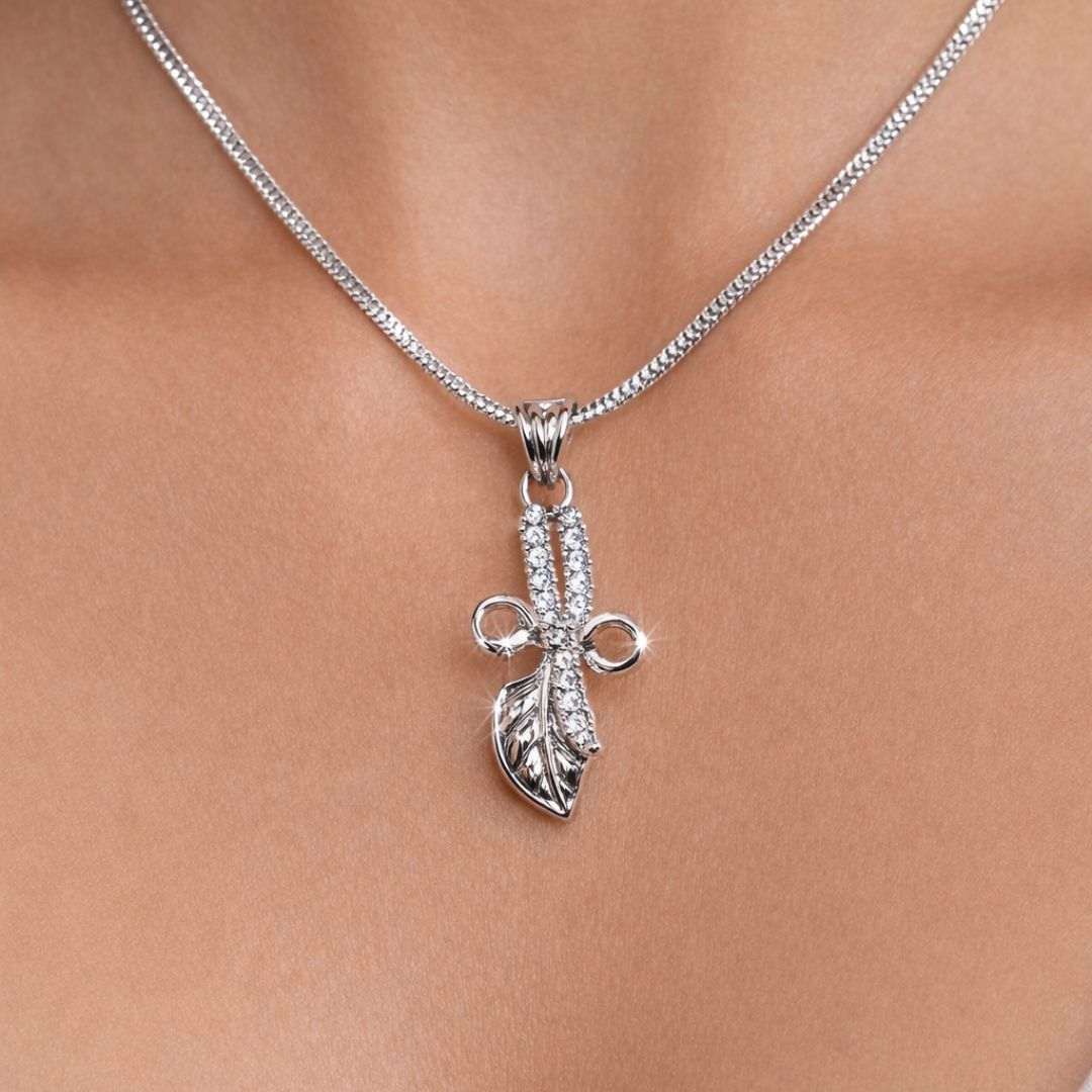 Silver necklace with a leaf pendant on a person's neck