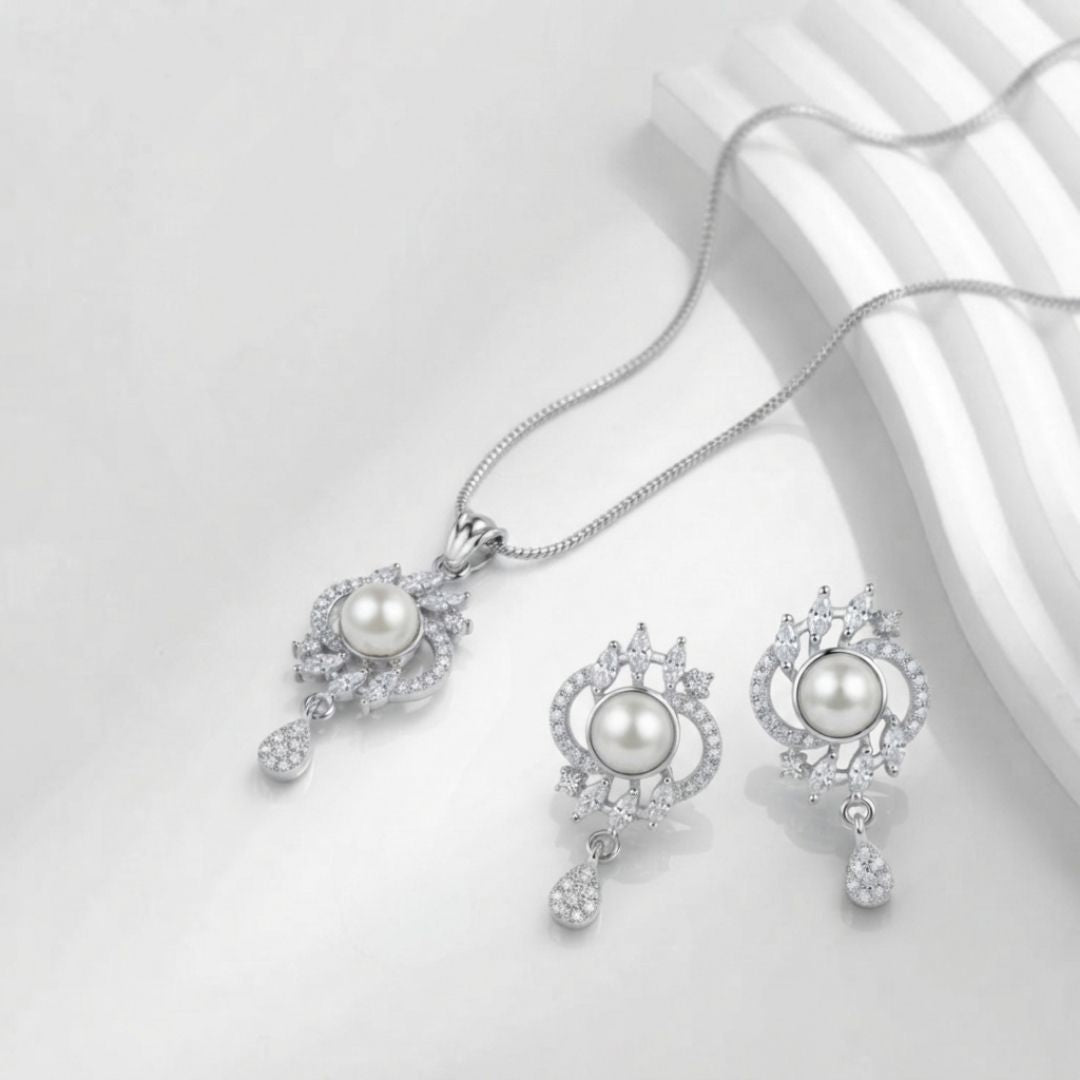 Silver necklace and earring set with central pearls and surrounding crystal accents