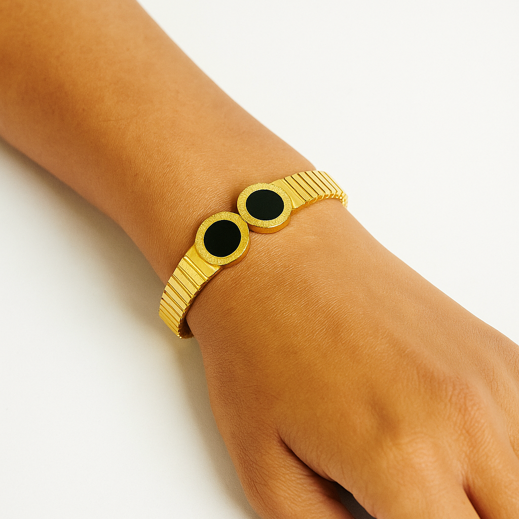 Gold Bracelet for Women with black stones on a wrist against a white background