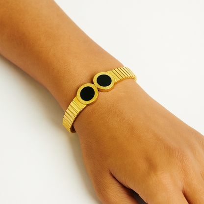 Gold Bracelet for Women with black stones on a wrist against a white background
