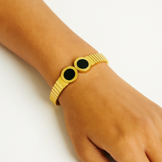 Gold Bracelet for Women with black stones on a wrist against a white background