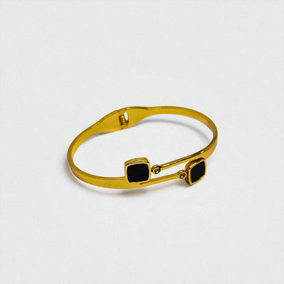 Gold Bracelet for Women with black square stones on a light gray background