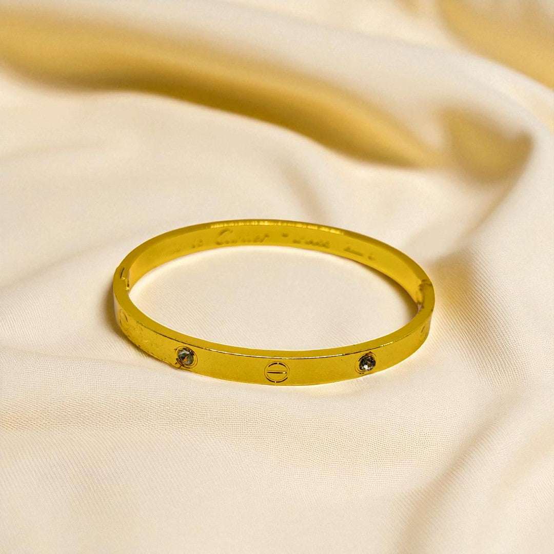 Gold Bracelet for Women with small stones on a beige fabric background