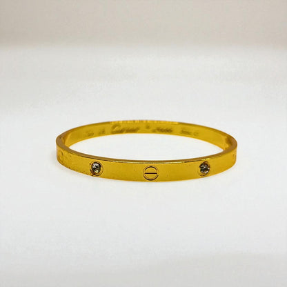 Gold Bracelet for Women with embedded stones on a light gray background