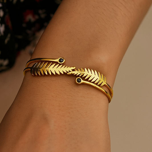 Gold Bracelet for Women with leaf design on a wrist against a neutral background