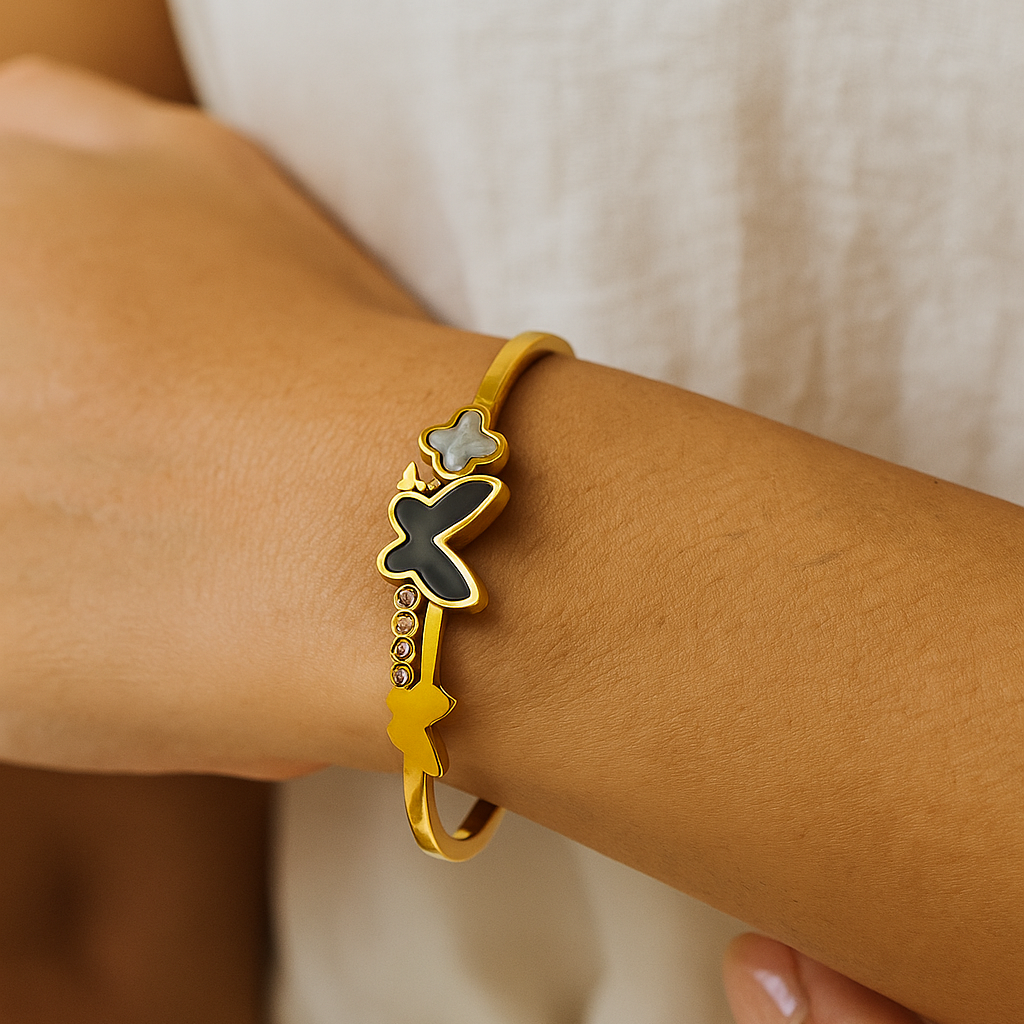 Close-up of a wrist wearing a gold Bracelet for Women with star and cross designs.