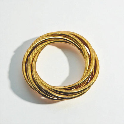 Gold Bracelet for Women on a wrist with a neutral background
