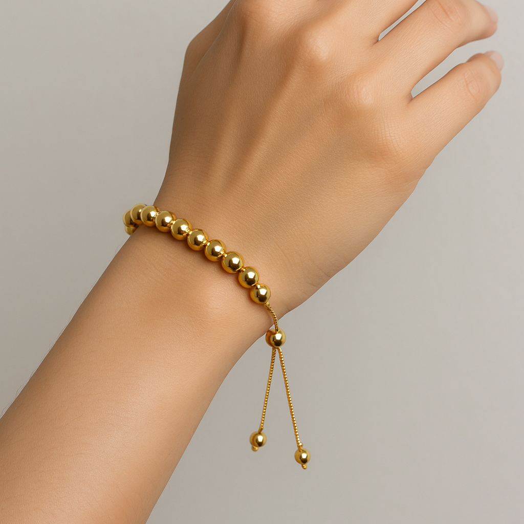 Gold beaded Bracelet for Women on a wrist against a neutral background