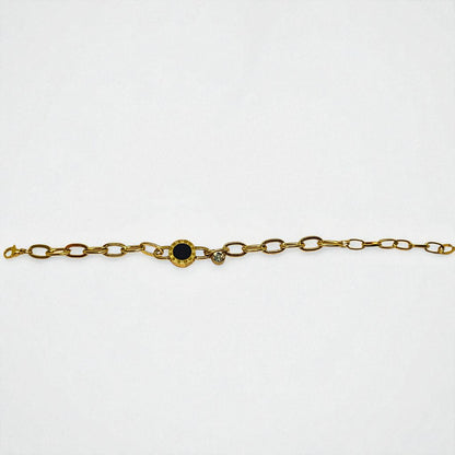 Gold Bracelet for Women with a black gemstone and smaller clear gemstones on a white background