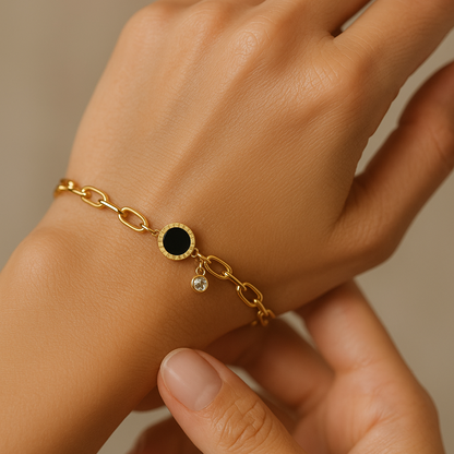 Gold Bracelet for Women with a black stone and clear gem on a wrist against a neutral background