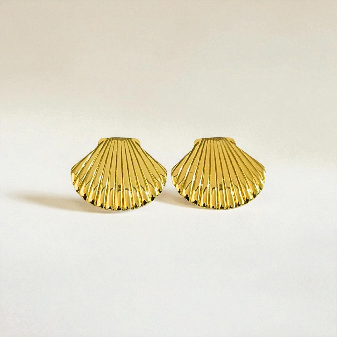 Gold shell-shaped Earrings for Women on a light beige background