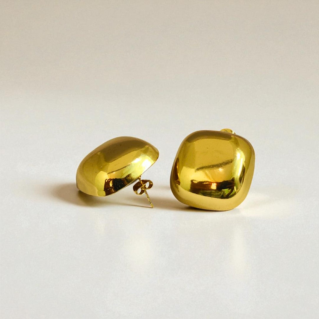 Pair of gold Earrings for Women on a light beige background
