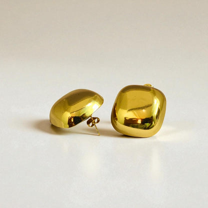 Pair of gold Earrings for Women on a light beige background