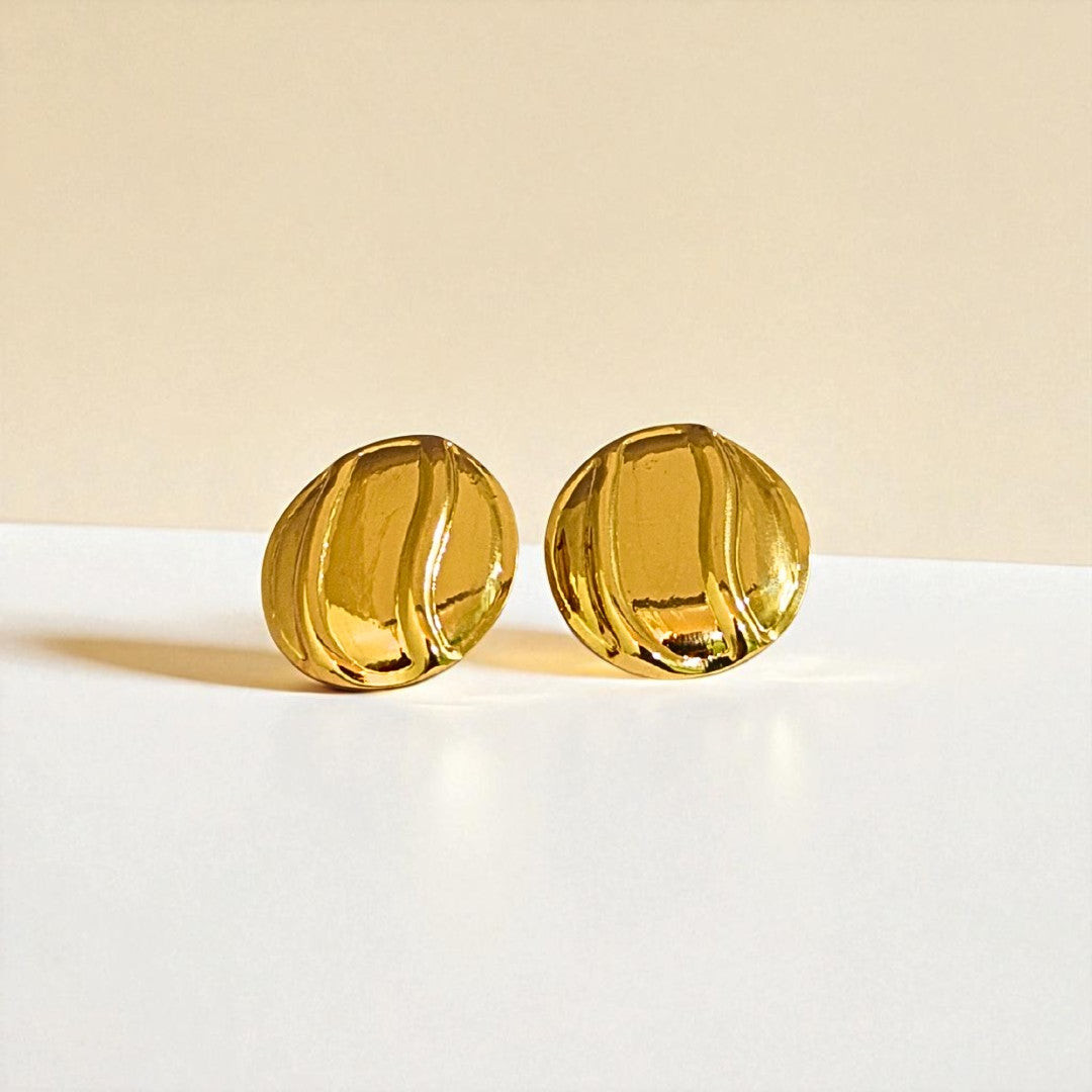 Gold Earrings for Women on a white surface with a beige background