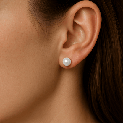 Close-up of an ear wearing a pearl earring with a blurred background