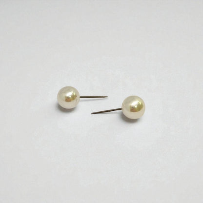 Pair of pearl stud earrings for women on a light gray background