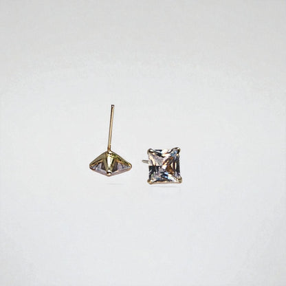 Pair of gold square-cut stud earrings for women on a light gray background
