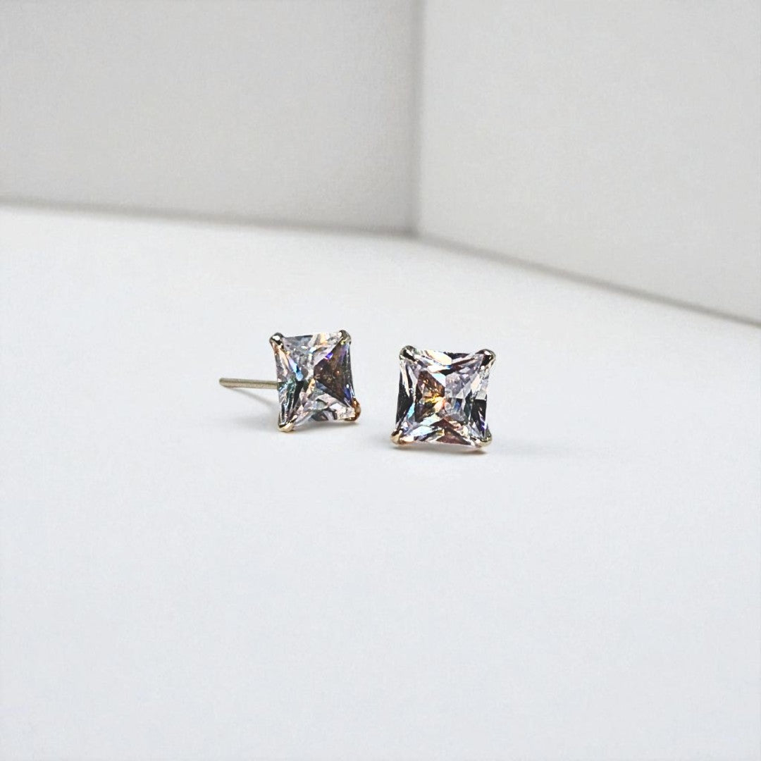 Pair of square-cut stud earrings for women on a light gray background