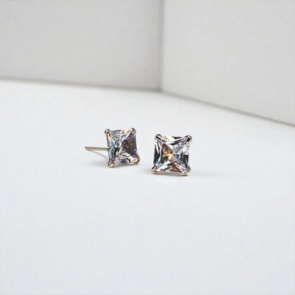Pair of square-cut stud earrings for women on a light gray background