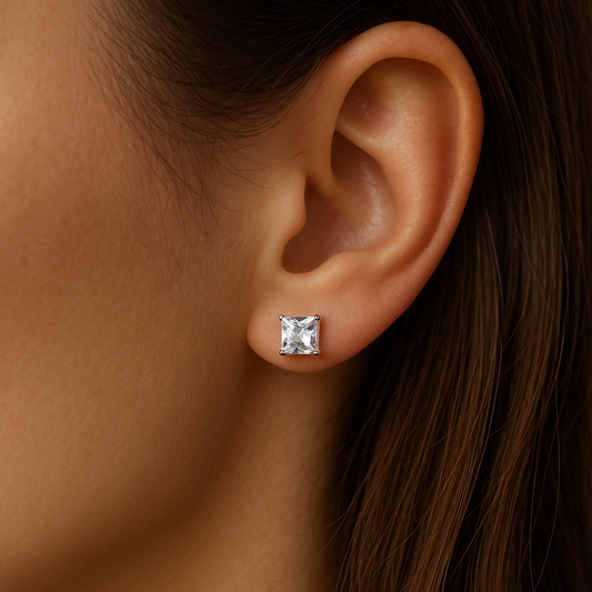 Close-up of an ear wearing a diamond stud earring with a blurred background