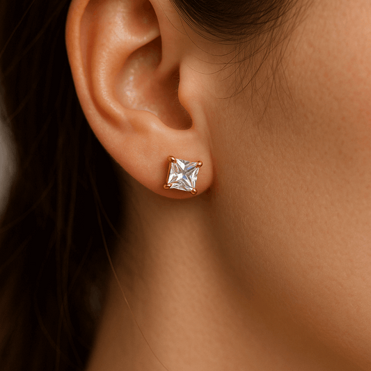 Gold earring for women with a clear gemstone worn by a person