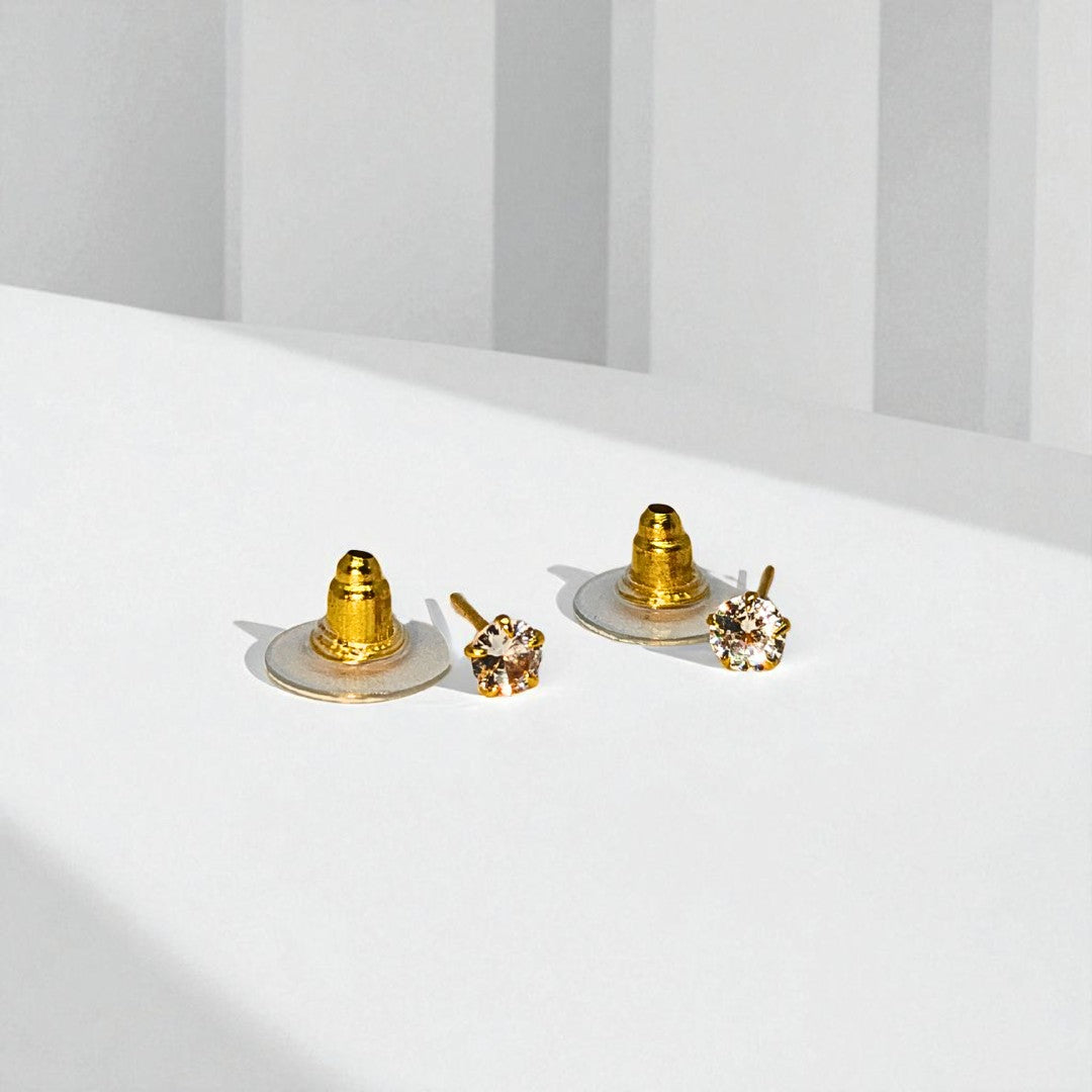 Set of gold and crystal Stud Earrings for Women on a white surface with a neutral background