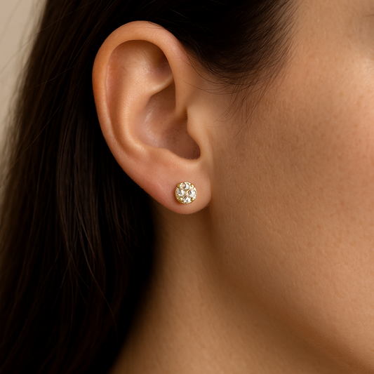Close-up of an ear wearing a gold Stud Earrings for Women with clear stones.