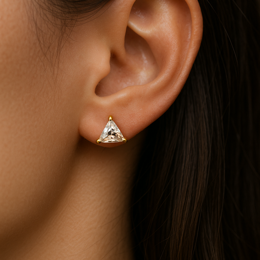 Close-up of an ear wearing a triangle-shaped Stud Earrings for Women with a dark background