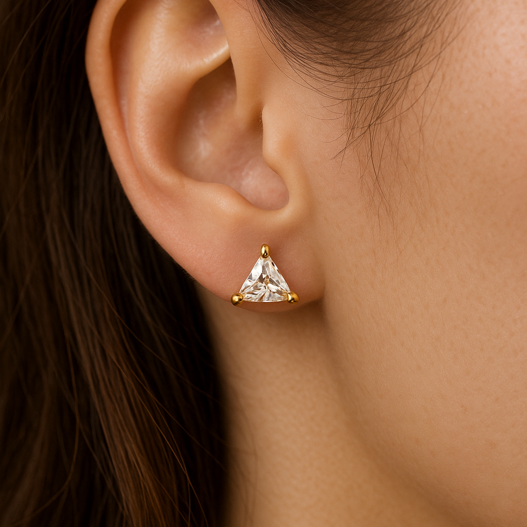 Close-up of an ear wearing a gold triangle-shaped Stud Earrings for Women.