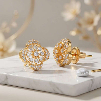 Gold earrings with diamond accents on a marble surface