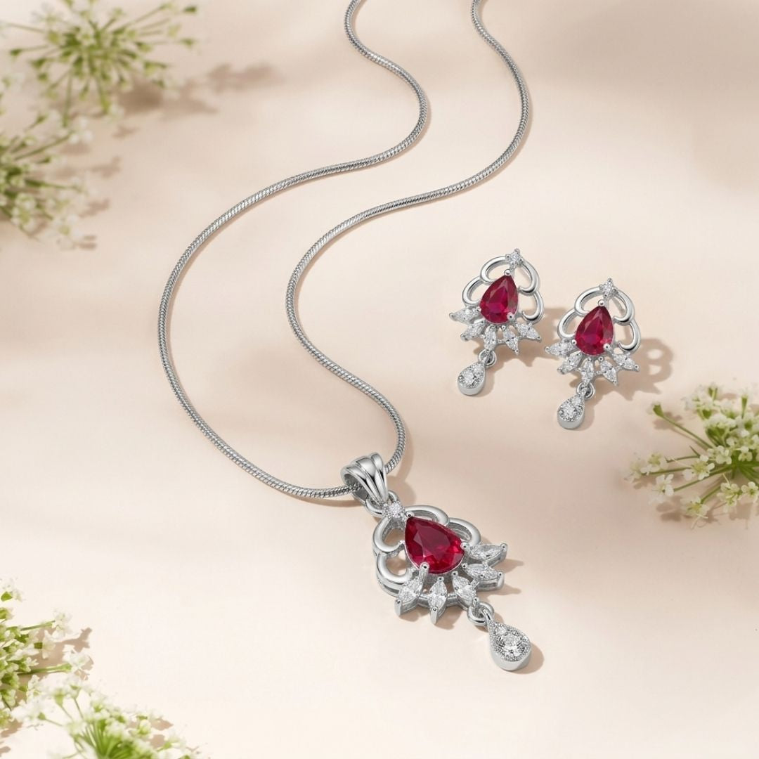 Silver necklace and earring set with pear shaped red stones and small white crystals