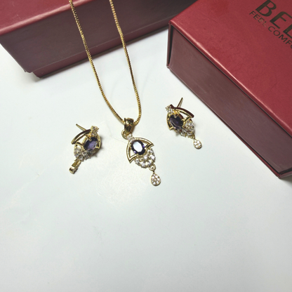 Gold jewelry set with necklace and earrings on a white surface, with a red box in the background.