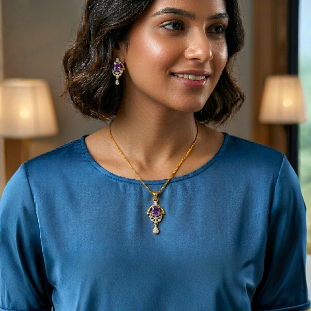 Woman wearing a gold necklace with a purple pendant and matching earrings indoors.