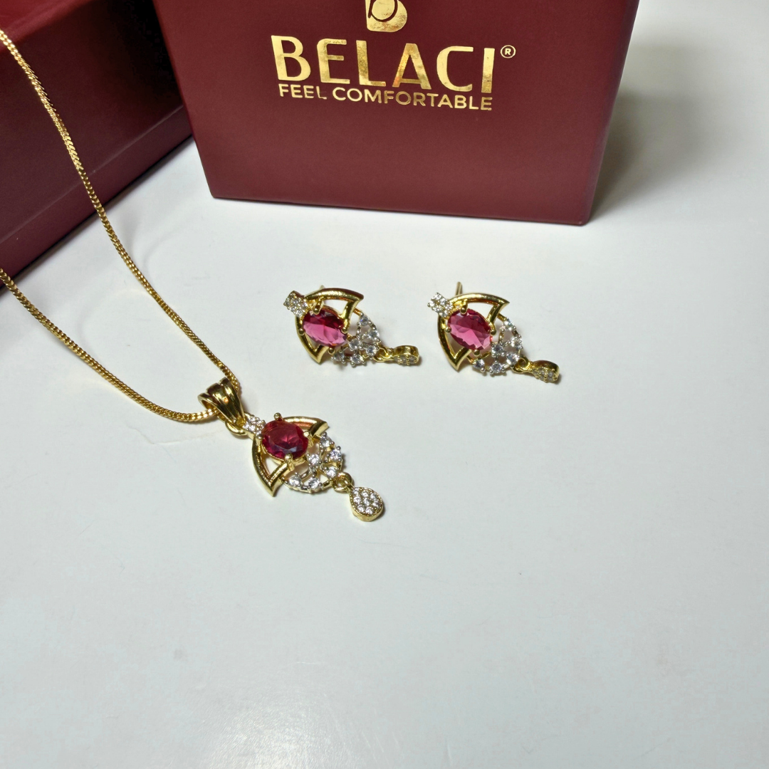 Gold jewelry set with pink gemstones in front of a Belaci box.