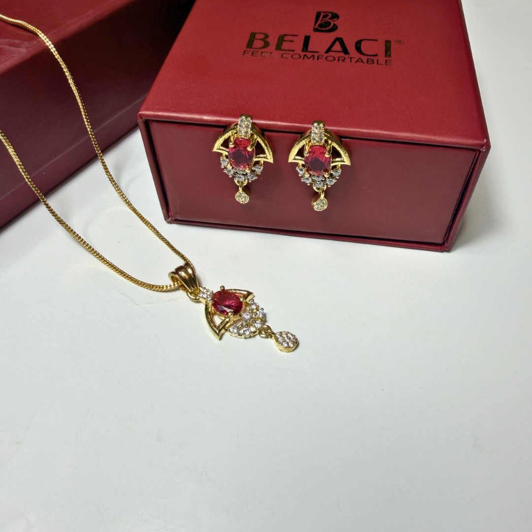 Gold jewelry set with red gemstones in front of a Belaci box.