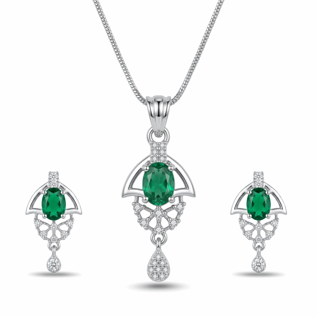 Jewelry set with emerald green gemstones and silver accents on a white background