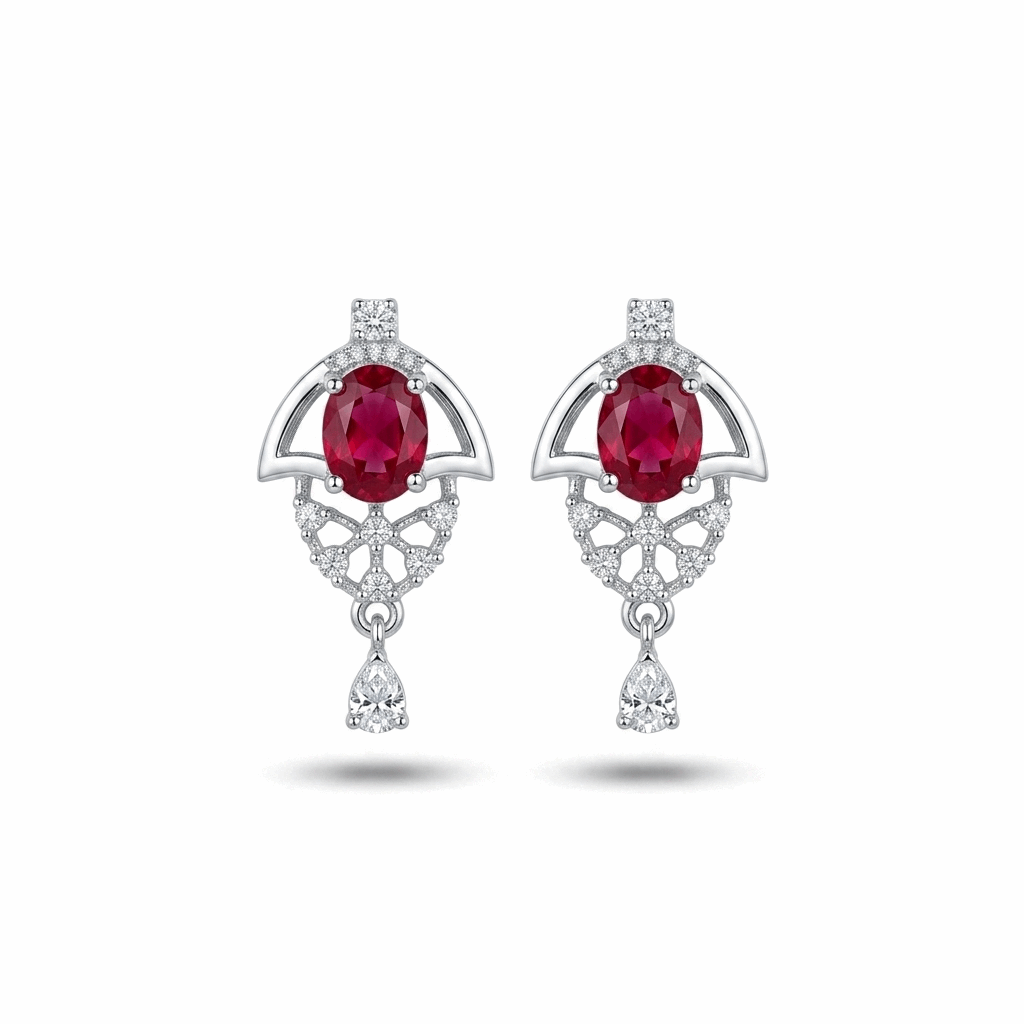 Pair of earrings with red gemstones and diamond accents on a white background