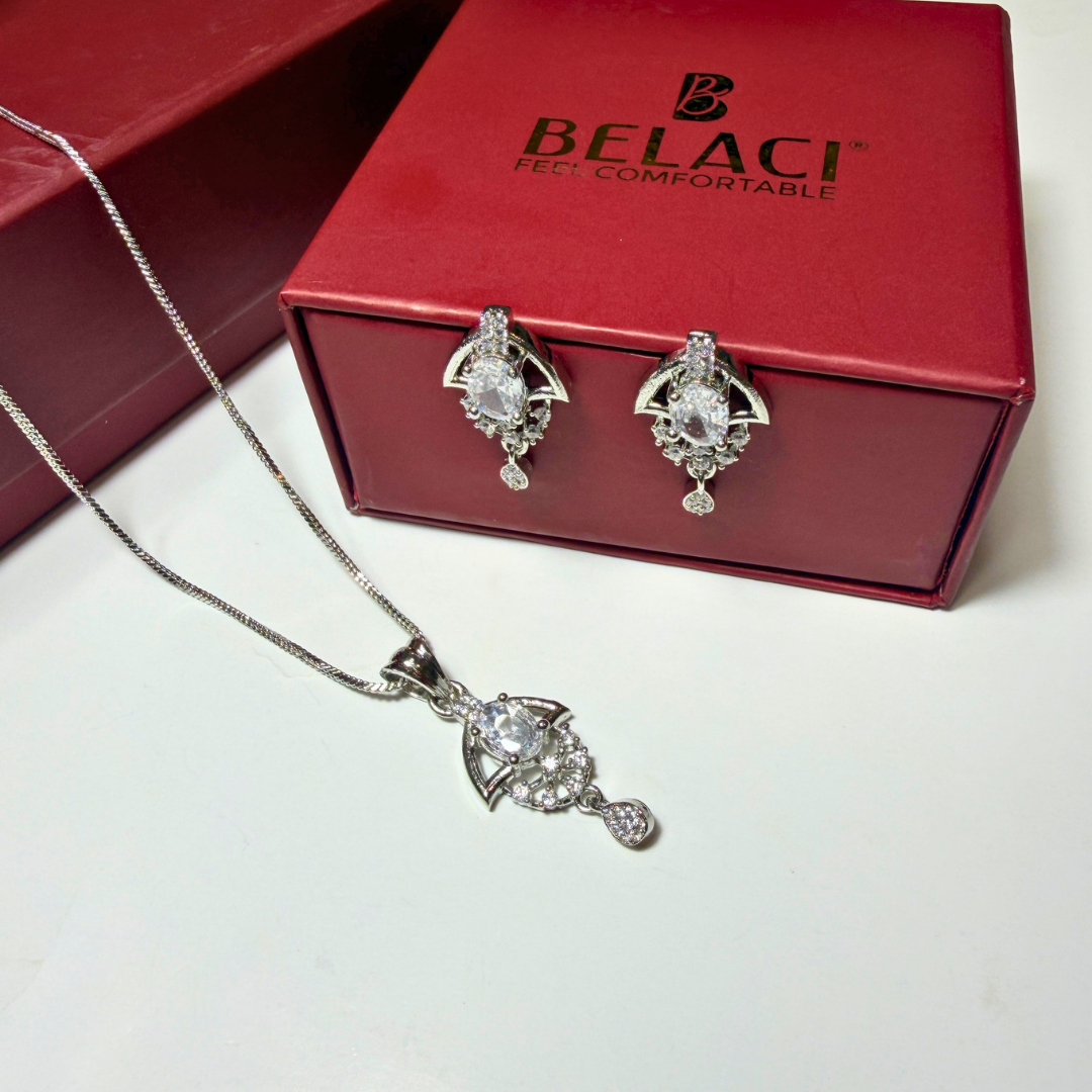 Silver jewelry set with necklace and earrings in front of a Belaci box.