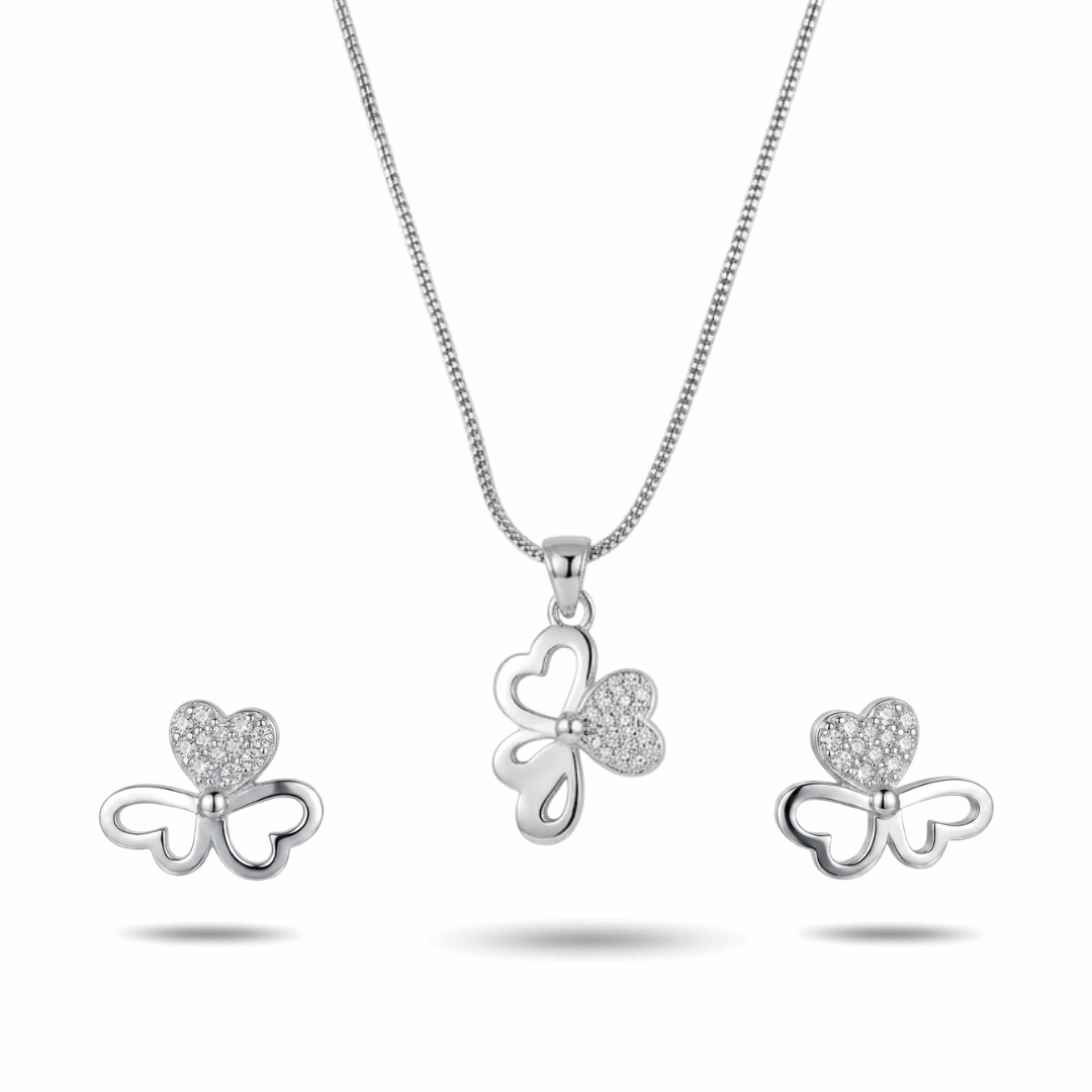 Silver bow-shaped jewelry set with heart details on a white background