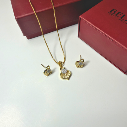 Gold jewelry set with necklace and earrings on a white surface with a red box in the background.