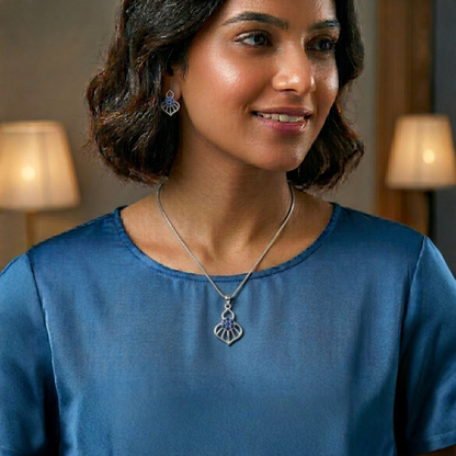 Woman wearing a silver necklace with a pendant in a warm indoor setting