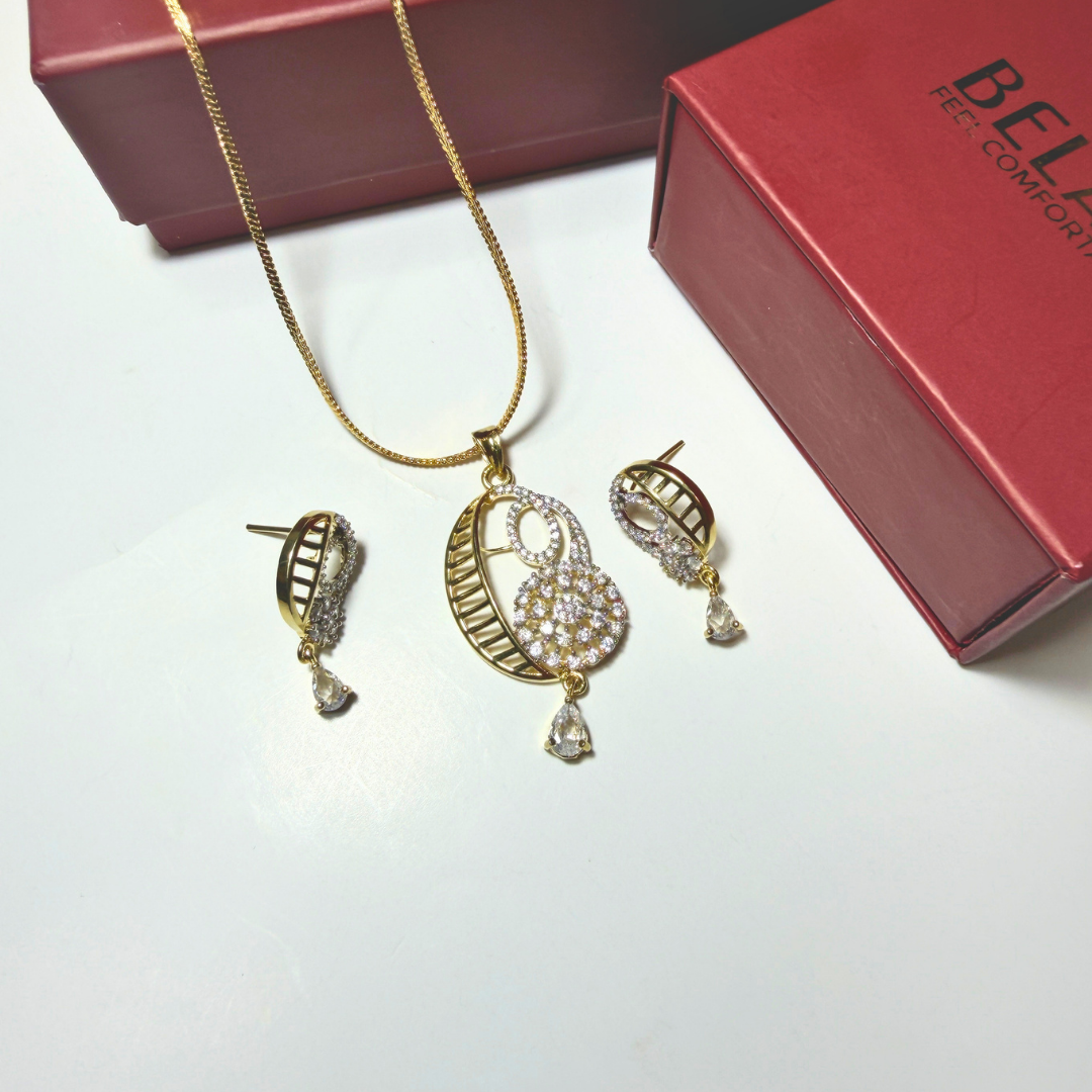 Gold jewelry set with necklace and earrings on a white surface, Beloved brand visible.