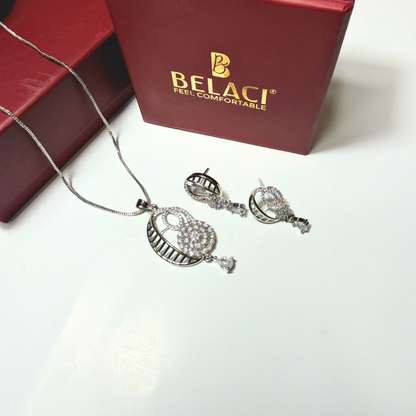 Silver jewelry set with necklace and earrings on a white surface, featuring the Belaci brand.