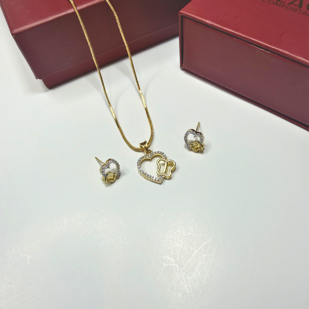 Gold heart-shaped jewelry set with matching earrings on a white surface.