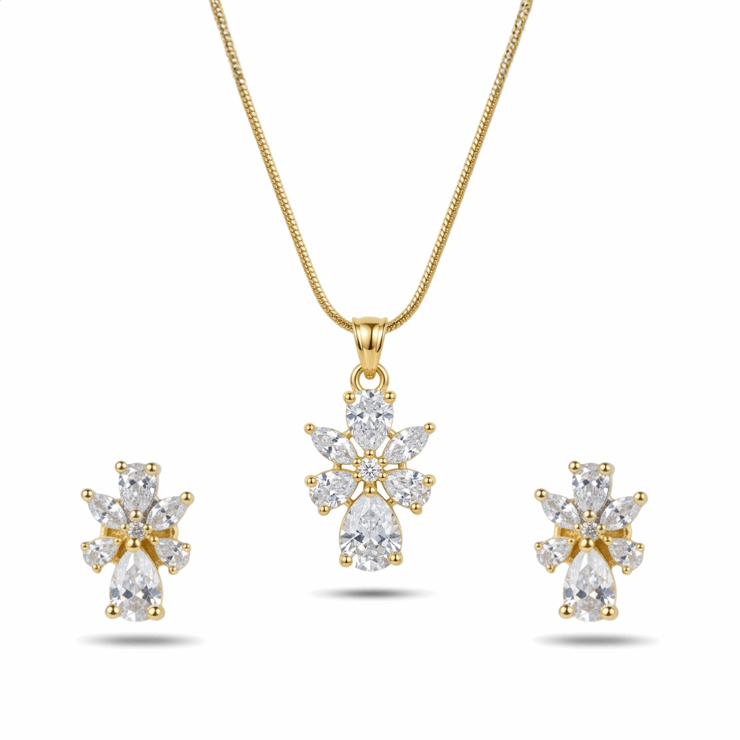 Gold necklace and earrings set with clear gemstones on a white background