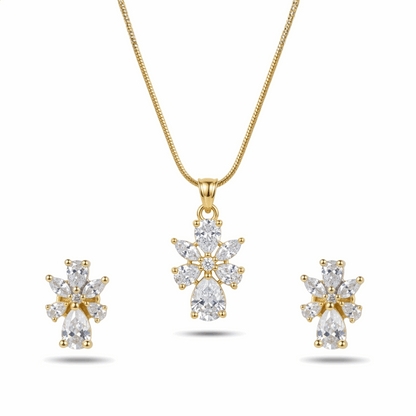 Gold necklace and earrings set with clear gemstones on a white background