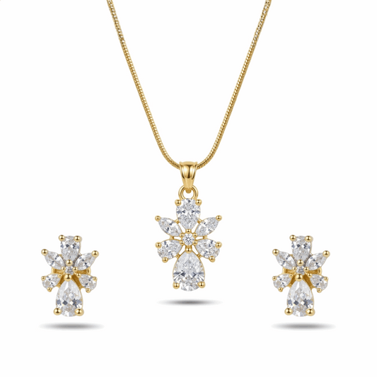 Gold necklace and earrings set with clear gemstones on a white background