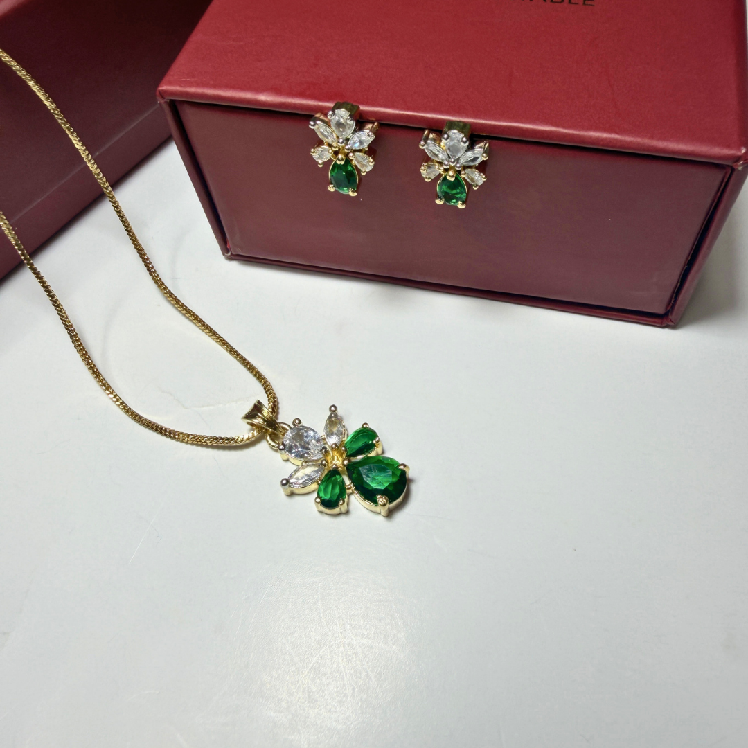 Jewelry set with pendant and earrings on a white surface with a red box in the background.