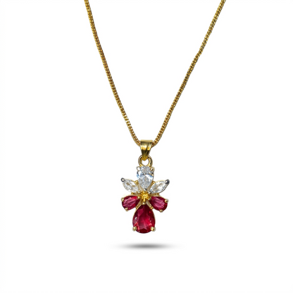 Gold necklace with a red gemstone pendant on a white background