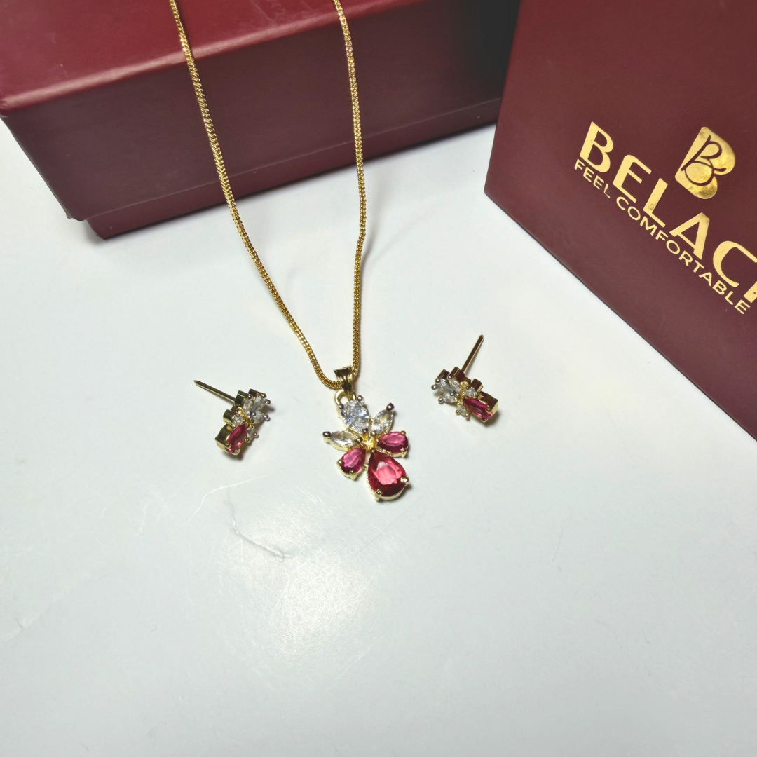 Jewelry set with necklace and earrings on a white surface next to a Belac box.